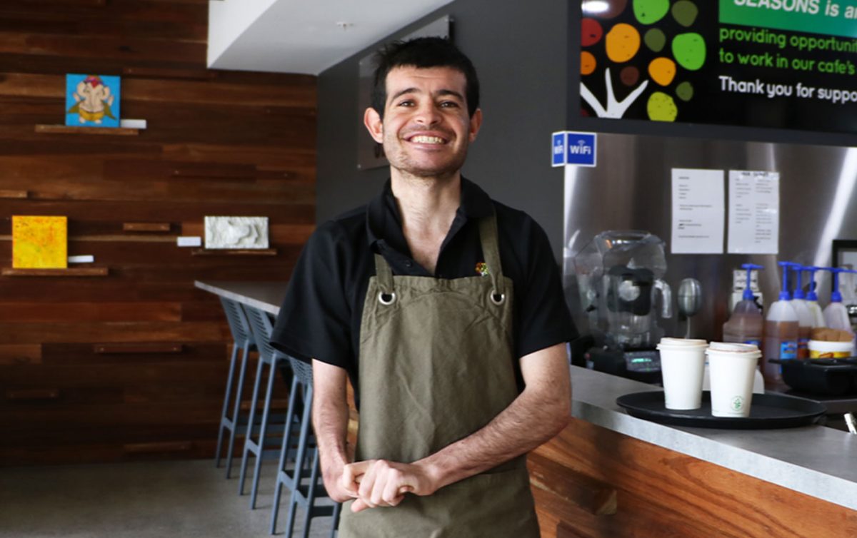 Man smiles wearing apron at Seasons Cafe