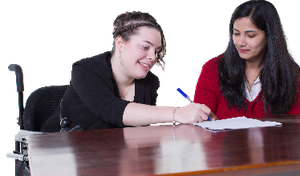 A person filling out some paperwork with a support worker