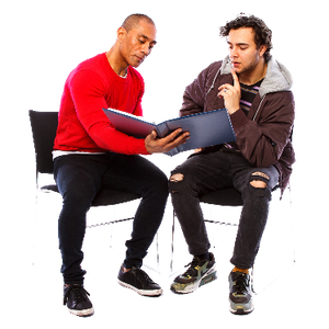 Two men sitting down reading a booklet together