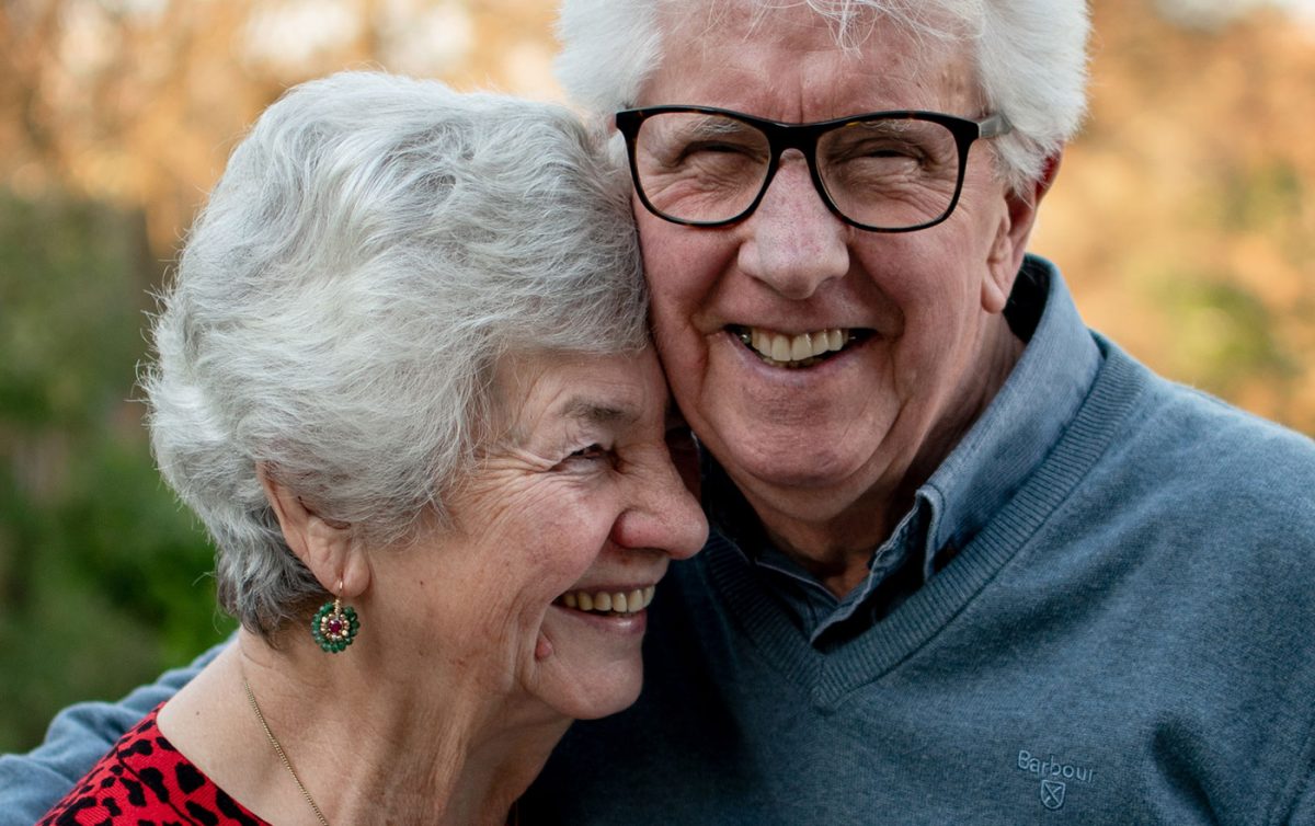 Aged care couple hugging and smiling