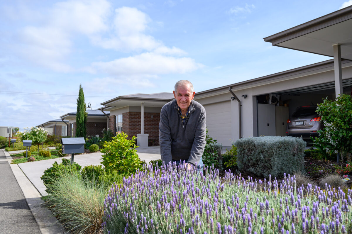 Barwarre Gardens resident Grant Goldsmith stands at front of unit in garden that includes lavender plant.